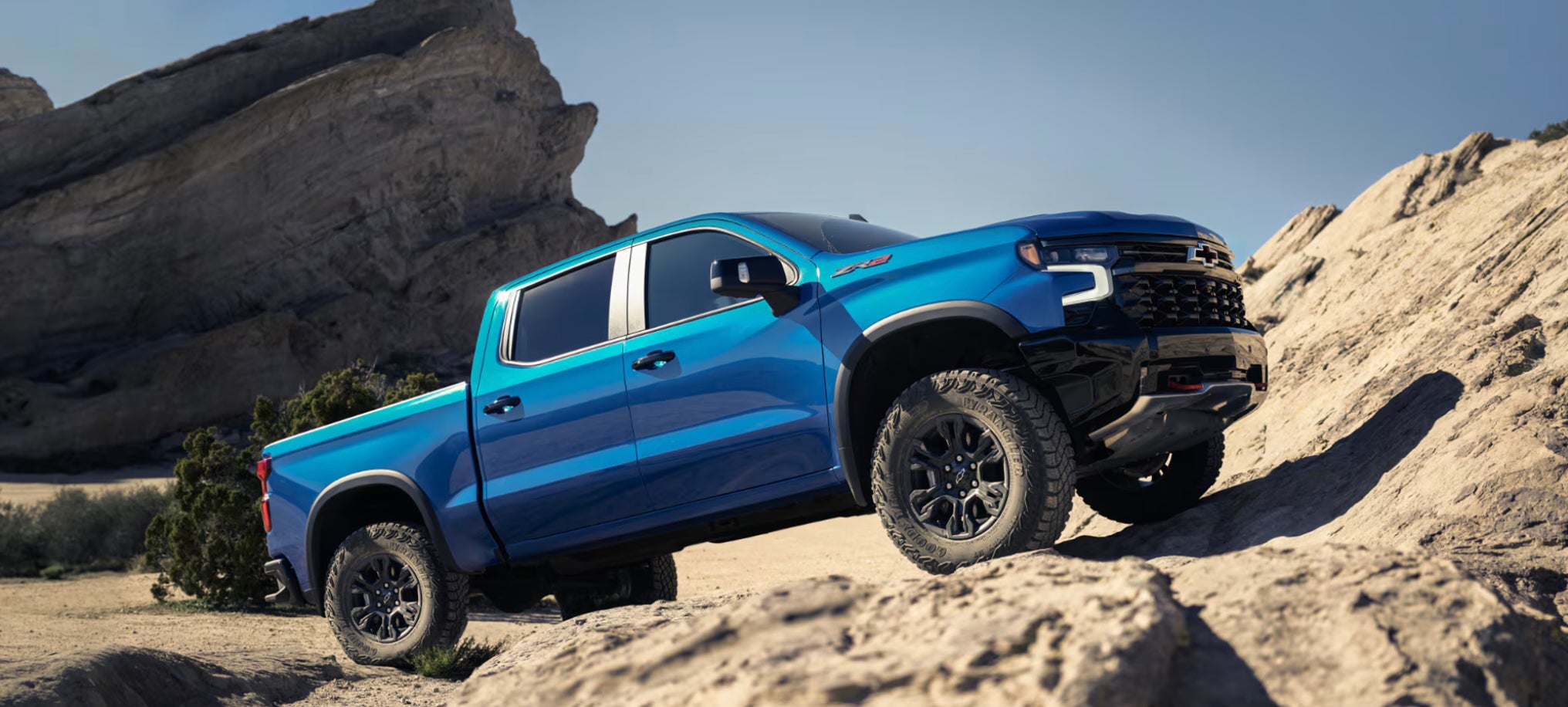 A bright blue 2026 Chevrolet Silverado 1500 pickup truck parked at a steep angle on some rocks